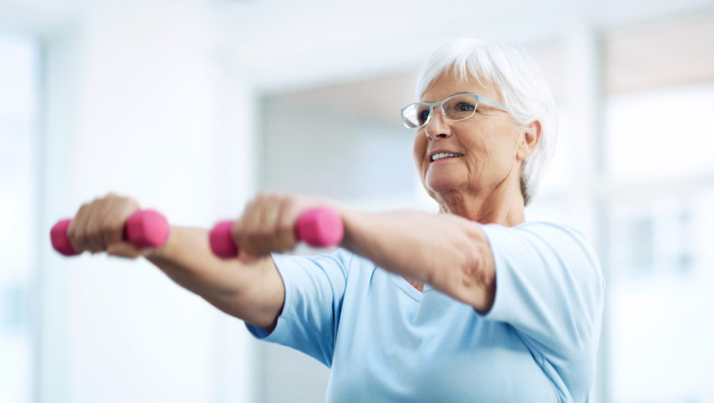 Older woman exercising to reduce the mental impact of COVID-19. 