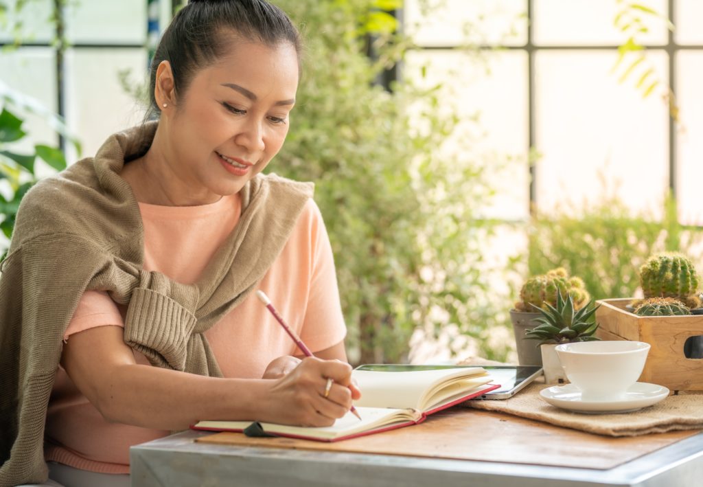 Woman journaling her thoughts and feelings as part of her self-care routine