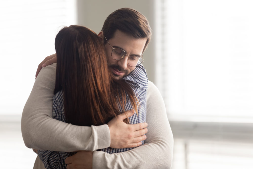 Family members combatting feelings of helplessness by hugging. 