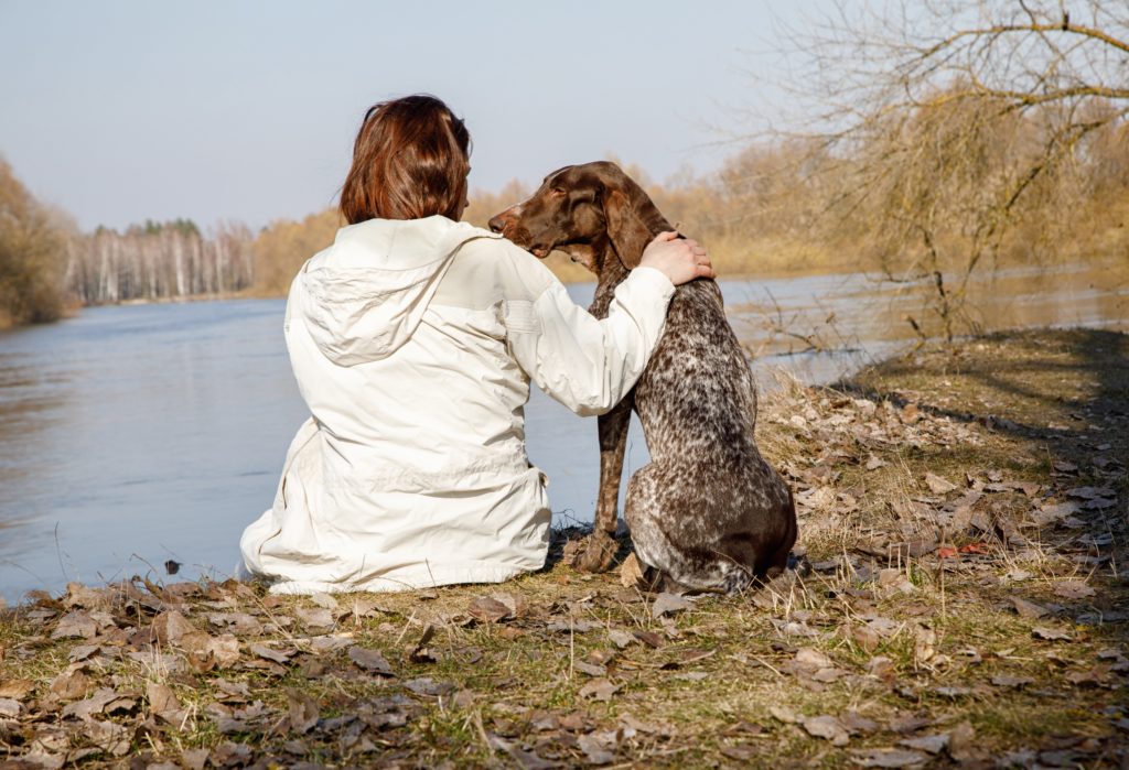 Woman engaging in an outdoor walk with her dog as a coping technique.  